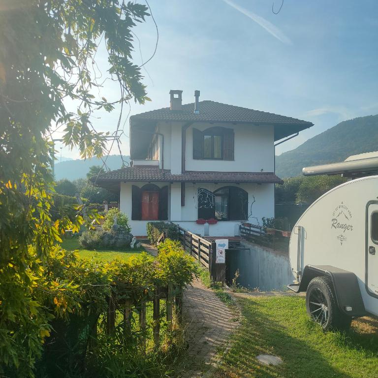 Uma casa branca com um reboque à frente. em Casa Jesus em Almese