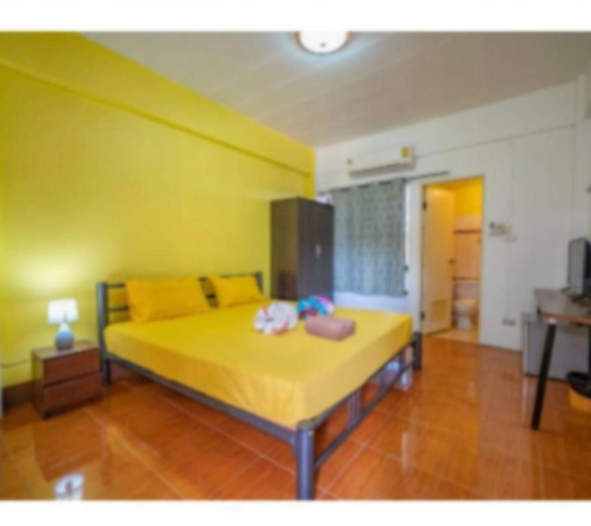 a bedroom with a yellow bed with two dolls on it at full house romance in Chiang Mai