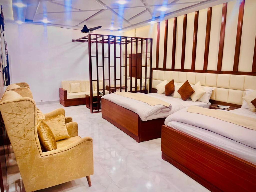 The Signature Hotel Multan في ملتان: غرفة فندقية بسريرين وكرسي