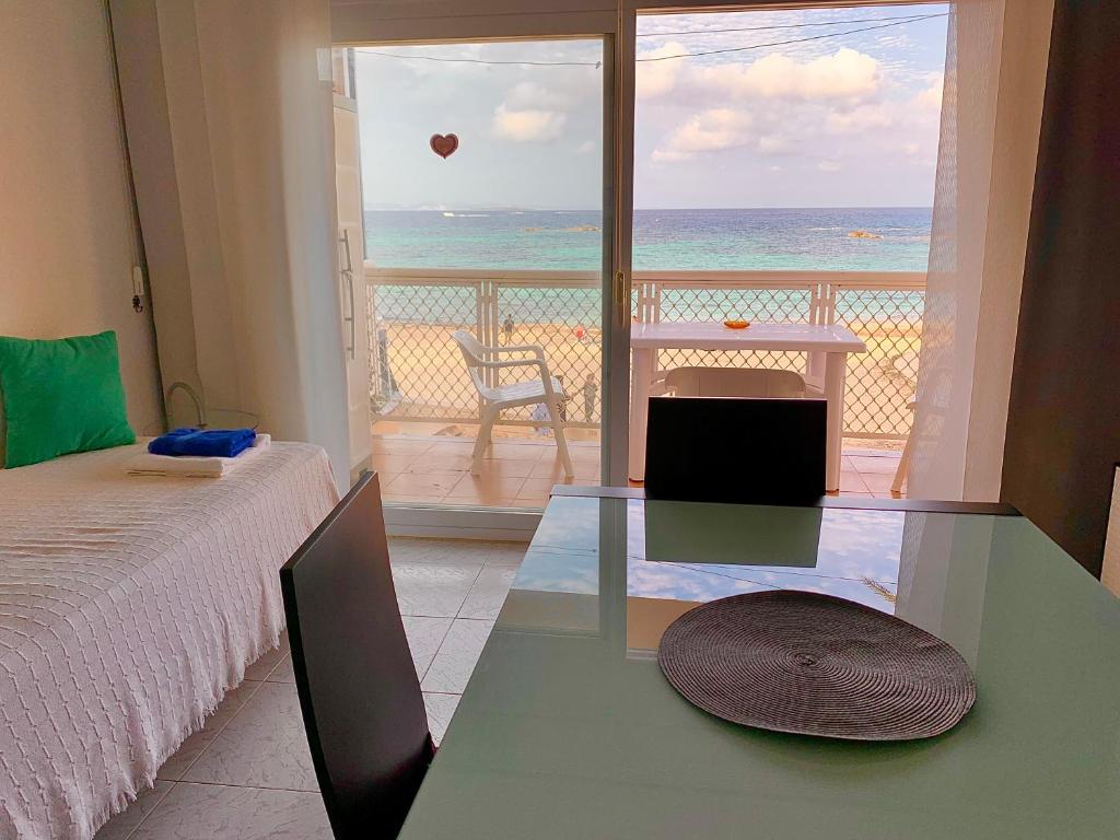 a bedroom with a bed and a view of the ocean at APT Borras & Roca Plana, fronte mare in Es Pujols