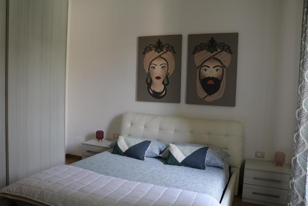 una camera con un letto con tre immagini appese al muro di Anna’s Home a Pompei