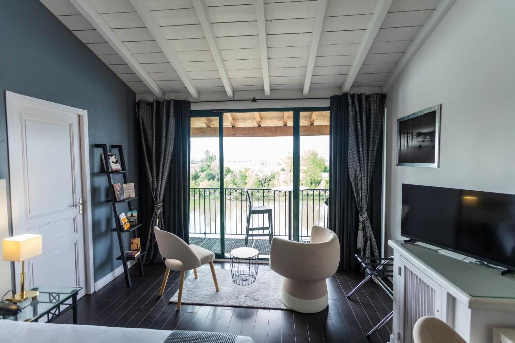 a bedroom with a view of a balcony at CÔTE GARONNE le BALCON DES DAMES -hôtel et restaurant- Tonneins Fauillet Marmande - panorama sur Garonne-climatisé- accueil vélo- soirée étape- chambre famille- étape et séjour touristique- in Tonneins