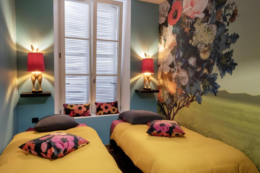 2 Betten in einem Zimmer mit 2 Lampen und einem Fenster in der Unterkunft LA BELL'CHAPELLE in Remiremont