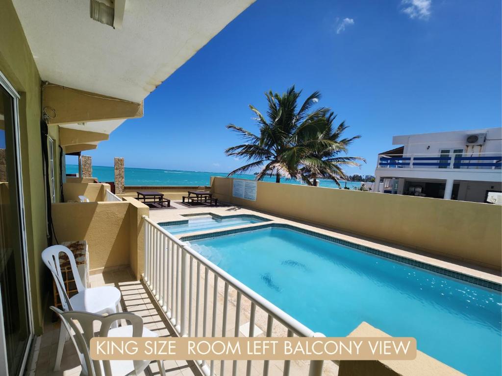 Selva Boutique Hotel - Luquillo Oceanfront Retreat في لوكويللو: حمام سباحة على شرفة شقة مع الشاطئ
