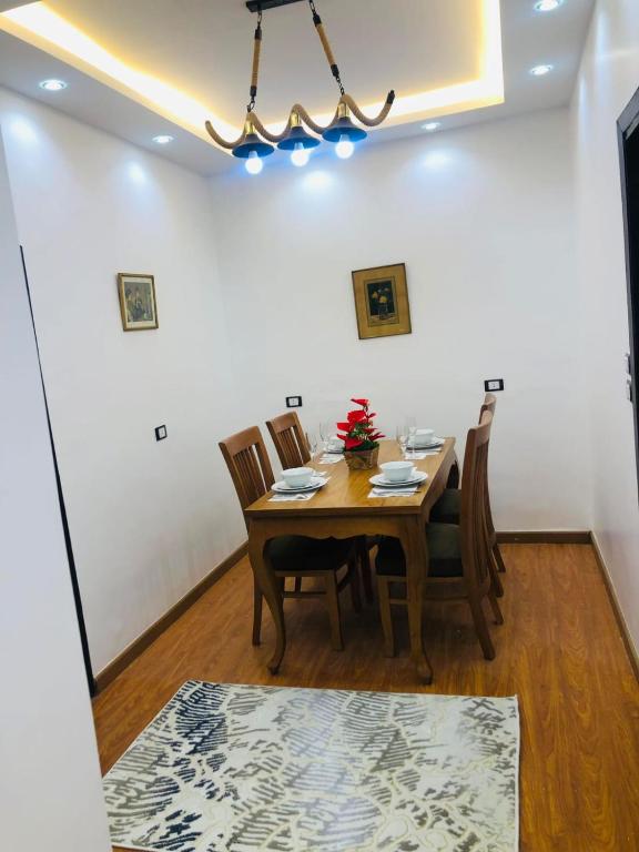 comedor con mesa de madera y sillas en شقه فندقيه ف ارقي مواقع بالزمالك en El Cairo