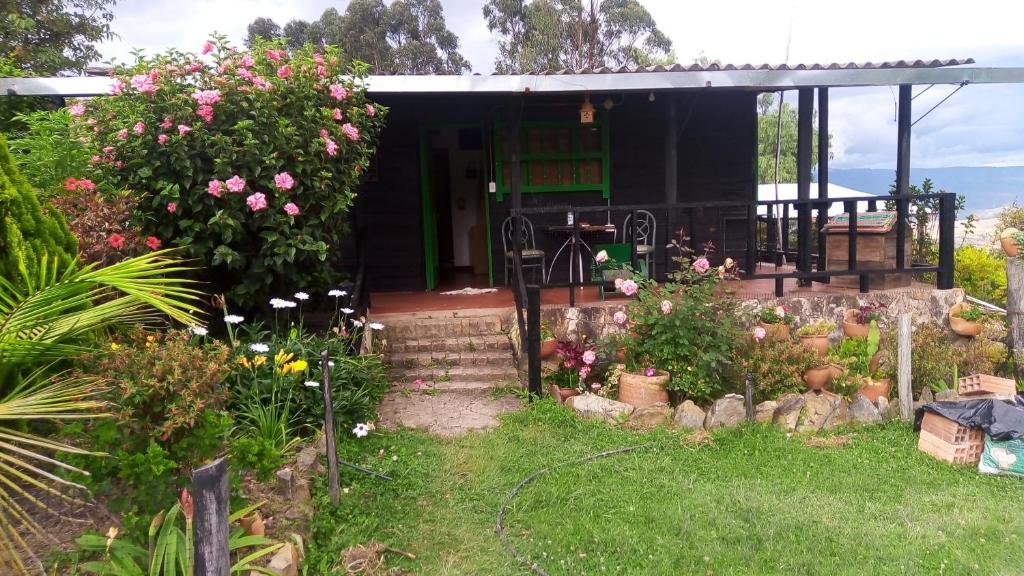 una piccola casa con dei fiori davanti di Finca la Riverita a Sutamarchán