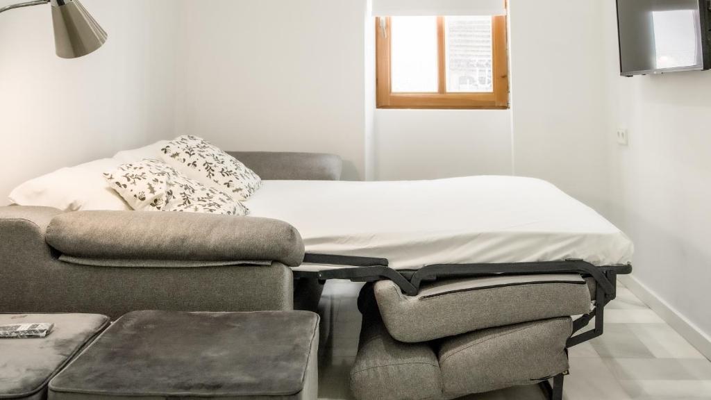 1 cama y 1 silla en una habitación en Catalina Suites Apartments Downtown Valencia en Valencia
