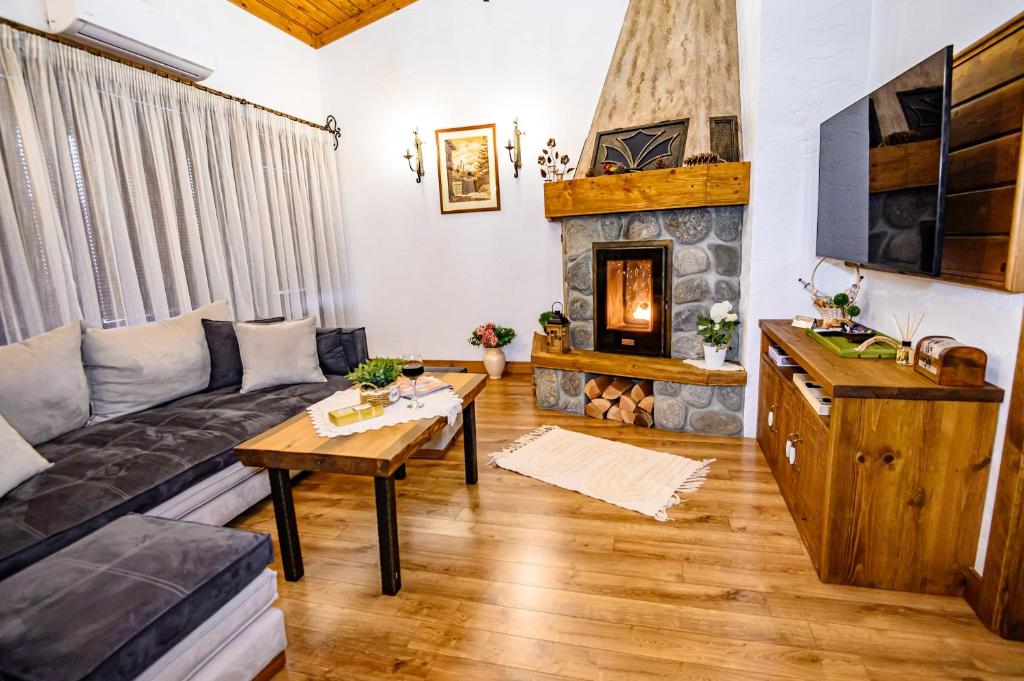 uma sala de estar com um sofá e uma lareira em Къща за гости Плевнята em Bansko