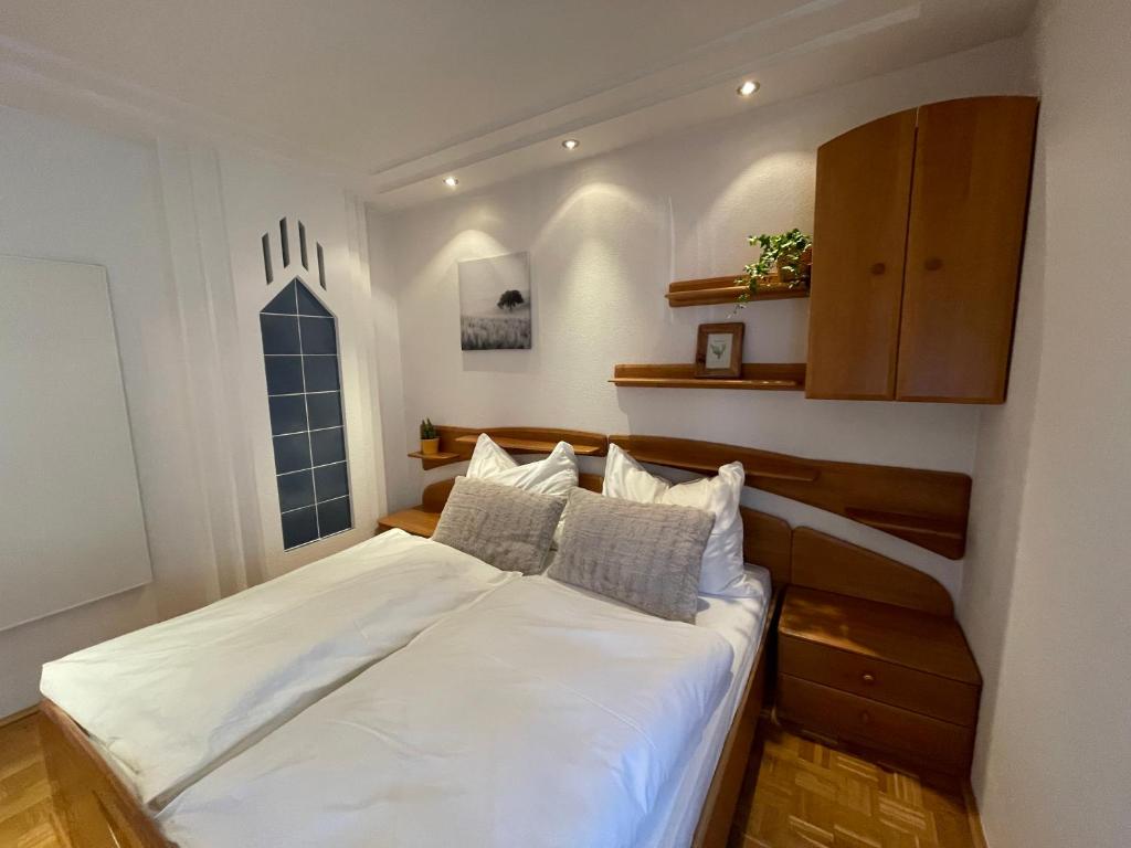 sypialnia z dużym łóżkiem z białą pościelą i poduszkami w obiekcie Moderne Wohnung in LKH Nähe w Grazu