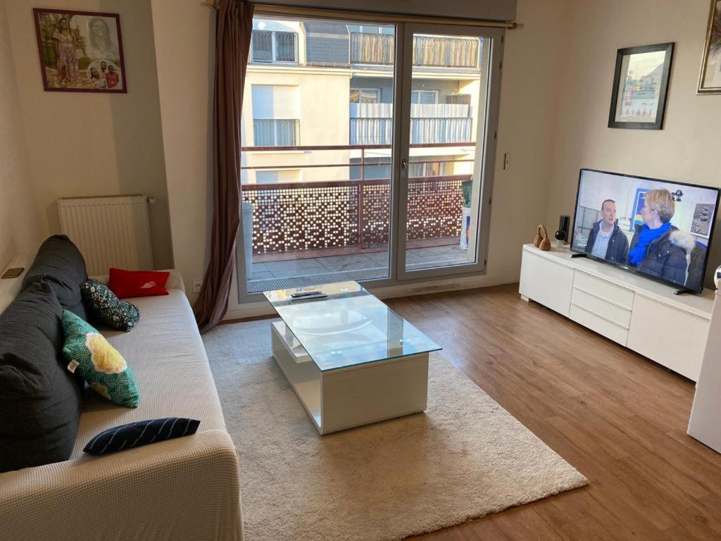 a living room with a couch and a tv at Appartement 3 pièces AlfortVille Centre in Alfortville