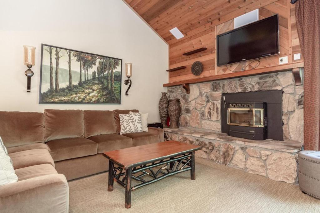 a living room with a couch and a fireplace at Snowflower #47 - Updated 2 Bedroom & Loft, 3 Bath, Sleeps 8, Steps away from Free Town Shuttle in Mammoth Lakes