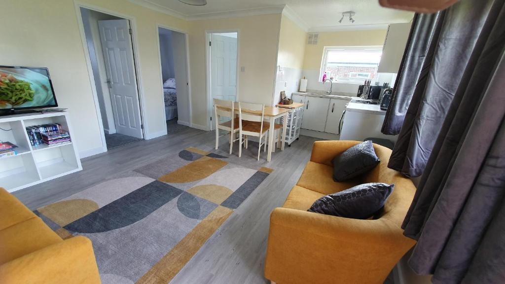 a living room with a couch and a table at 89 Florida Park in Hemsby