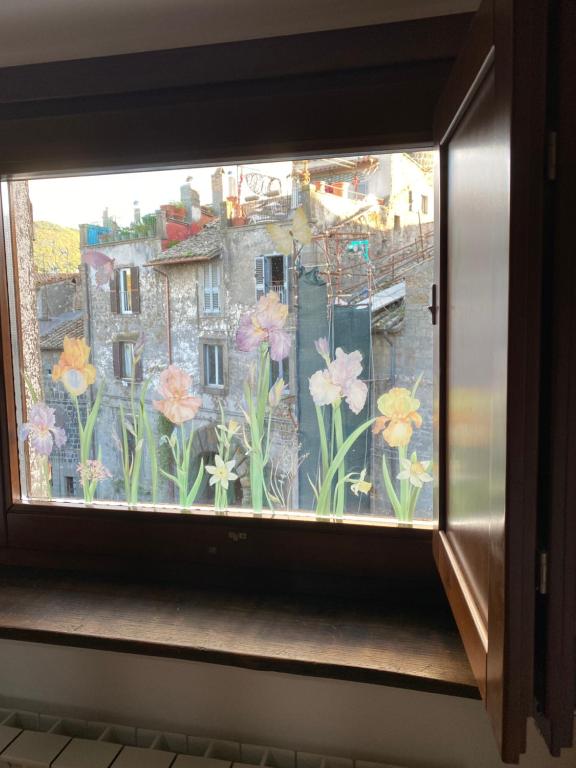 a window with a view of flowers on it at civico 8 in Viterbo