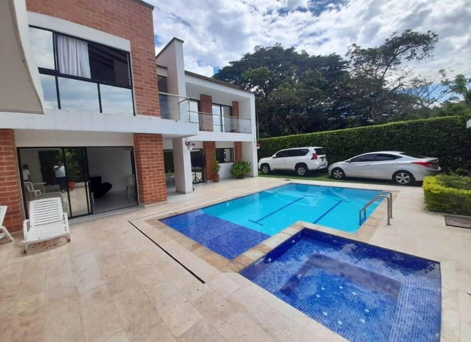 une villa avec une piscine en face d'une maison dans l'établissement Casa Campestre con piscina, à San Jerónimo