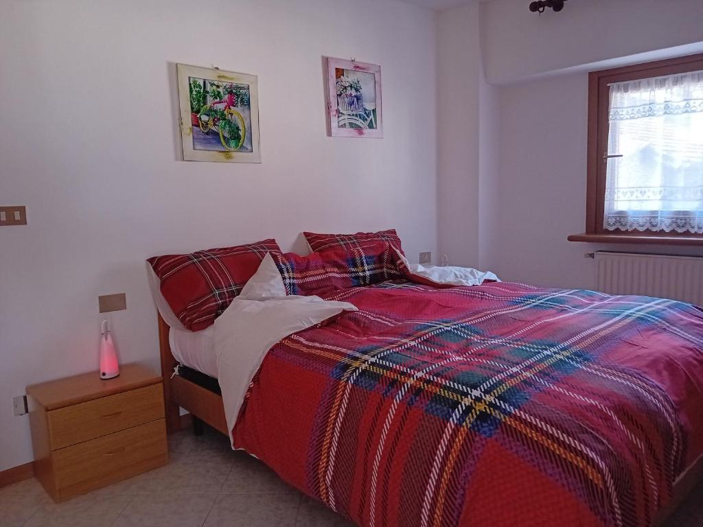 聖洛倫索巴納勒的住宿－Alloggio la Falesia，一间卧室设有红色的床和窗户。