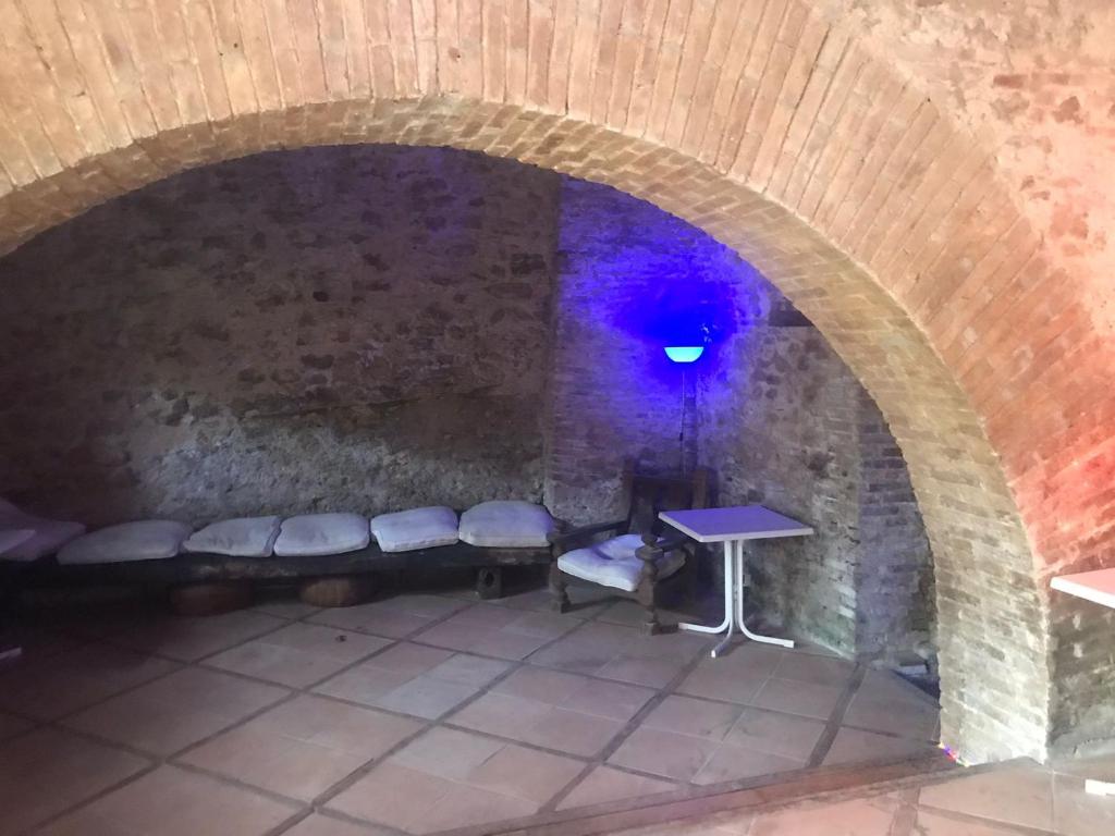 Habitación con pared de piedra, mesa y bancos en Cantina della musica per eventi en San Polo