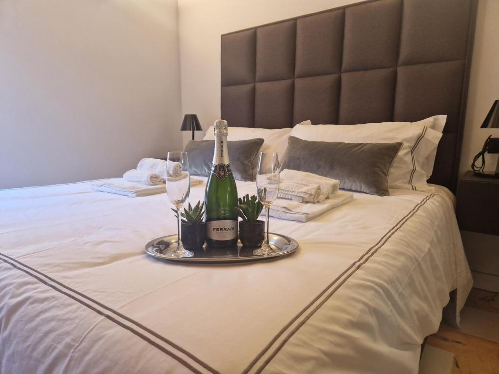 een fles champagne en glazen op een bed bij Corso Suite Style in Rome