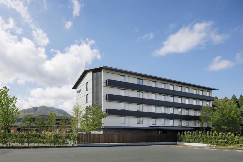 un gran edificio blanco con muchas ventanas en Fairfield by Marriott Kumamoto Aso en Aso