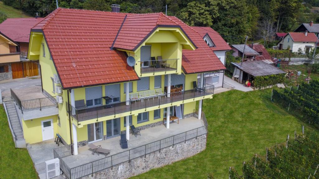 a large yellow house with red roof at Yellow House Grabrovec in Metlika