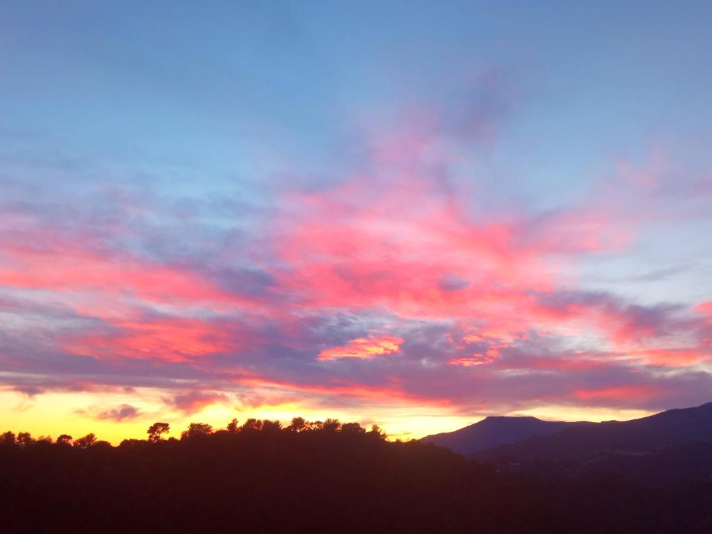 a sunset with red clouds in the sky at Message in a Bottle Bed and Breakfast in Camporosso