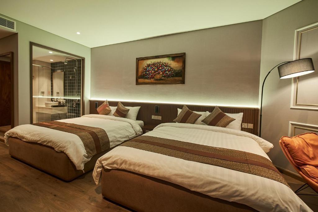 2 camas en una habitación de hotel con baño en Apec Mandala Wyndham Mui Ne Ngoc Linh en Ấp Long Sơn