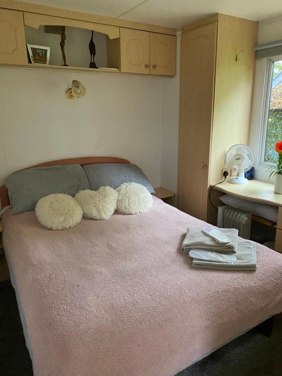 a bedroom with a bed with two fuzzy pillows on it at Monks Heath fold mobile home in Macclesfield