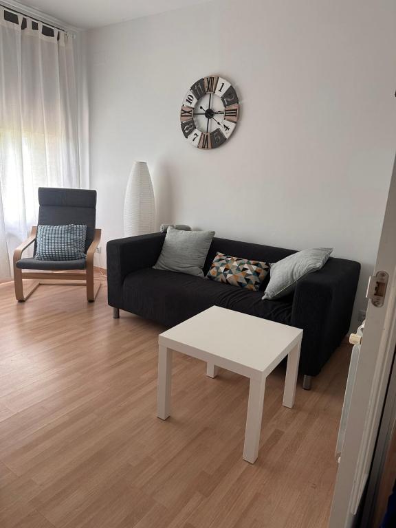 a living room with a black couch and a white table at Ruta del ferro in Ripoll