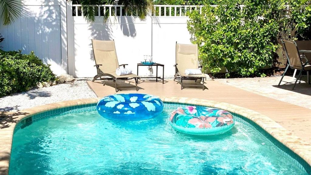 twee opblaasbare bedden in een zwembad in een achtertuin bij Debby's Place home in Holmes Beach