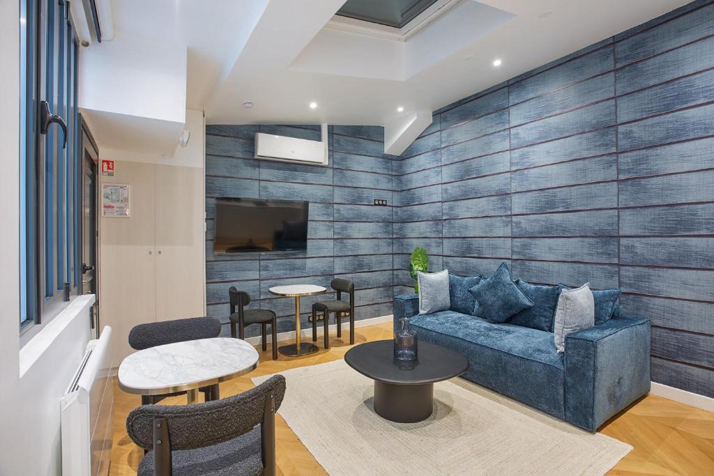 un salon avec un canapé bleu et des tables dans l'établissement Apartment Saint Germain des Prés by Studio prestige, à Paris