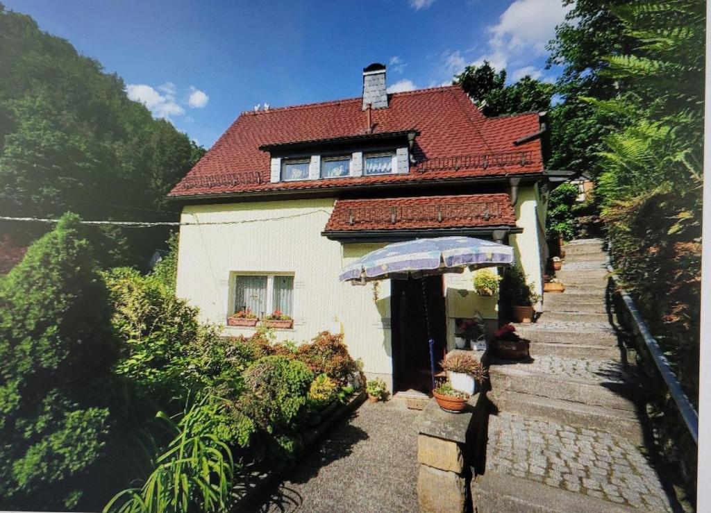 dom z parasolką przed nim w obiekcie Ferienhaus Sonnenblick Schmilka w mieście Schmilka