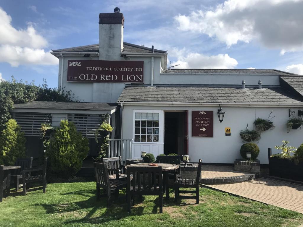 um edifício com uma mesa e cadeiras em frente em The Old Red Lion Inn em Cambridge