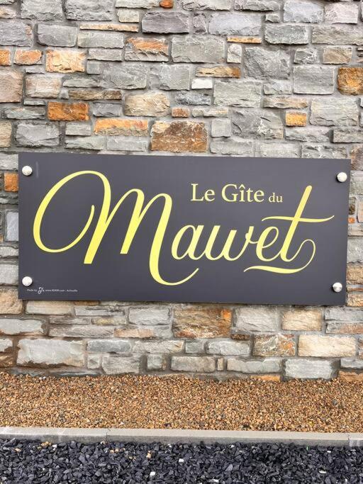 een bord voor een markt op een bakstenen muur bij Le gîte du Mawet in Léglise