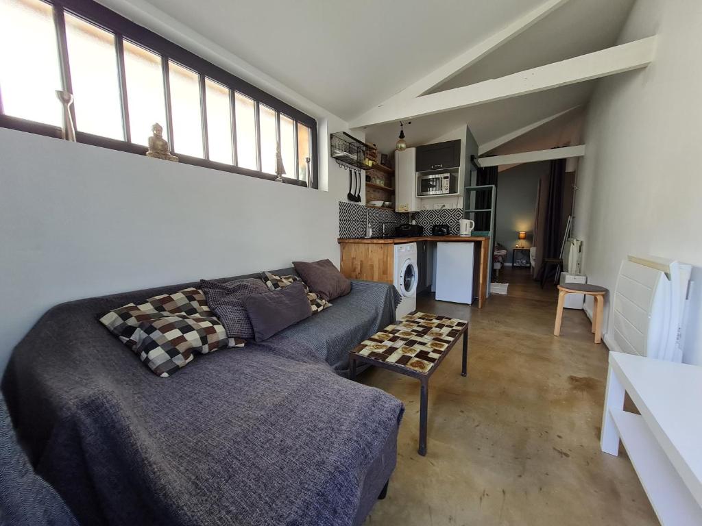 ein Wohnzimmer mit einem Sofa und einem Tisch in der Unterkunft Studio 22m2 proche Paris in Pierrefitte-sur-Seine