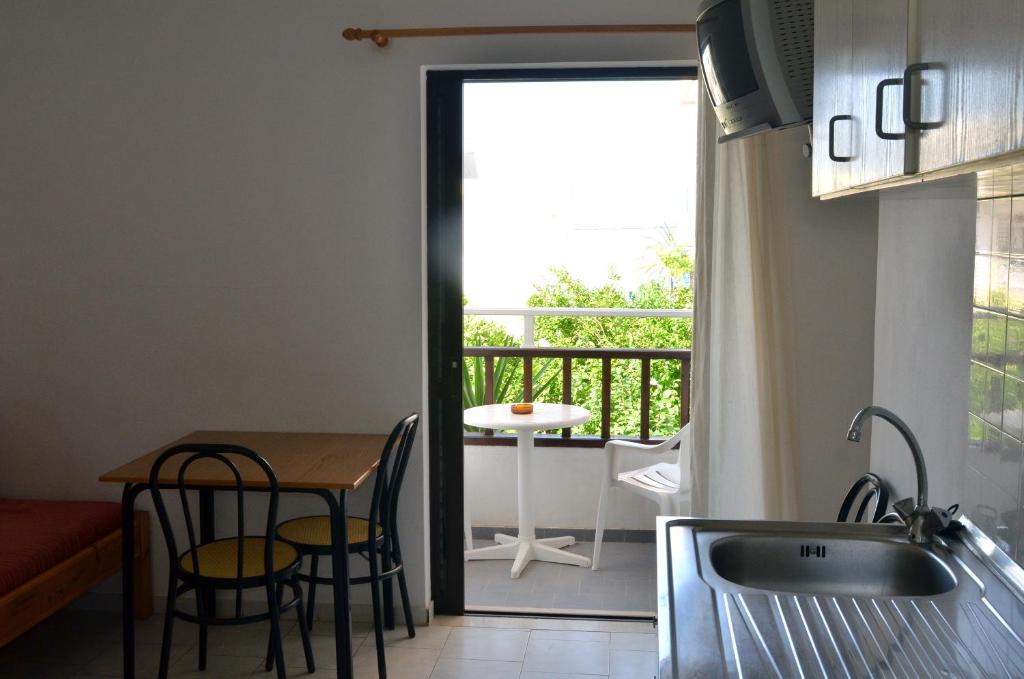 a kitchen with a table and a view of a balcony at Hotel Thisvi in Stalís