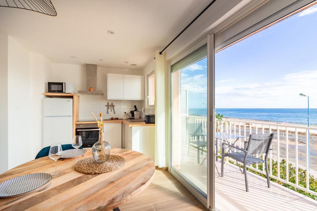 a kitchen and dining room with a view of the ocean at "La Sorra" Résidence en Bord de mer in Saint Cyprien Plage