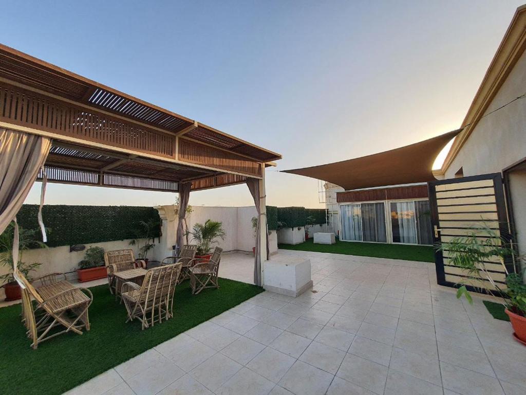 a patio with chairs and tables on a house at Paradise Studios in Sheikh Zayed