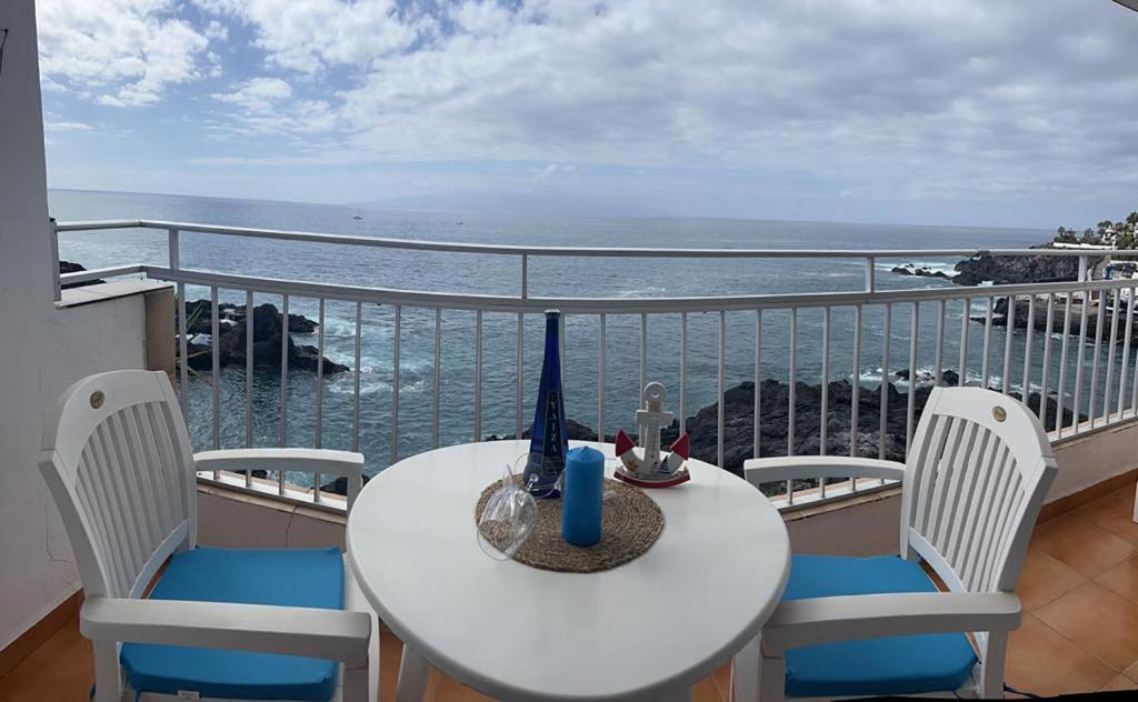 una mesa y sillas en un balcón con vistas al océano en Casa Angelmar by Apartamentos Estrella del Norte en Puerto de Santiago
