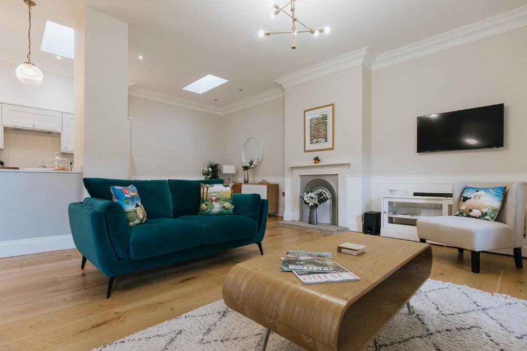 uma sala de estar com um sofá azul e uma mesa em SWALEDALE, OLD SCHOOL ROOMS - Luxury Apartment in Richmond, North Yorkshire em Richmond