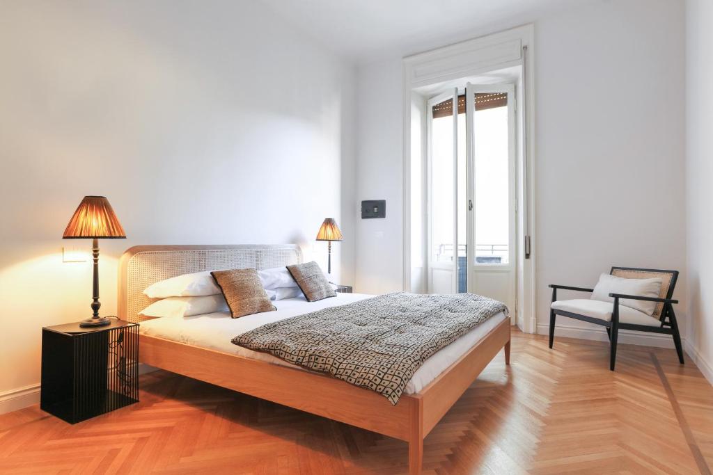 1 dormitorio con 1 cama grande y 1 silla en Adelaide Elegant apartments en Milán