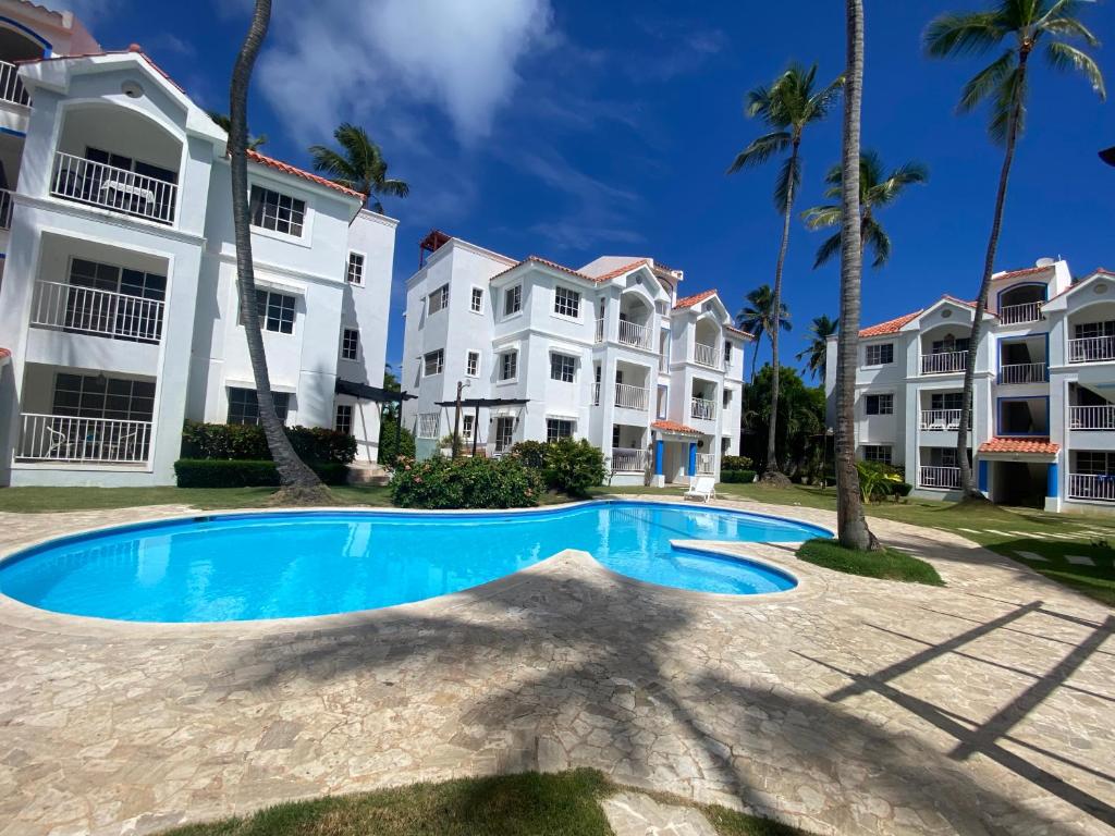 einen Pool vor einigen Apartmentgebäuden in der Unterkunft Madonna Pool Beach los Corales in Punta Cana
