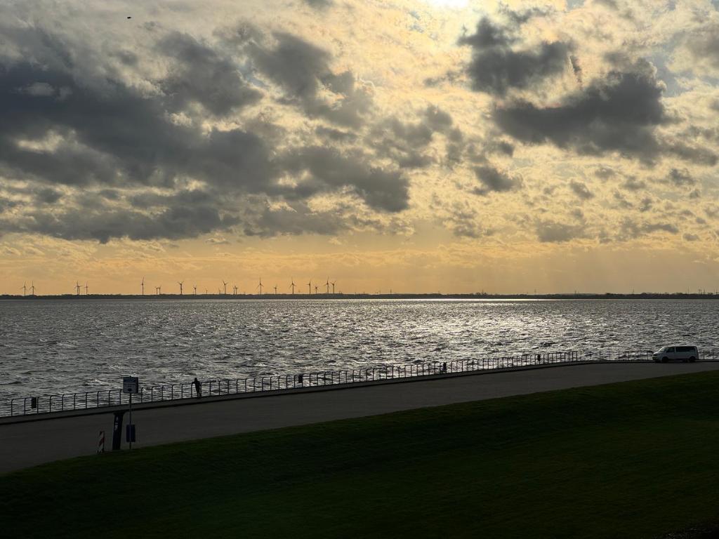 ein großer Wasserkörper mit wolkigem Himmel in der Unterkunft Strand-Penthouse, 128 qm, Maisonette, Parkplatz in Wilhelmshaven