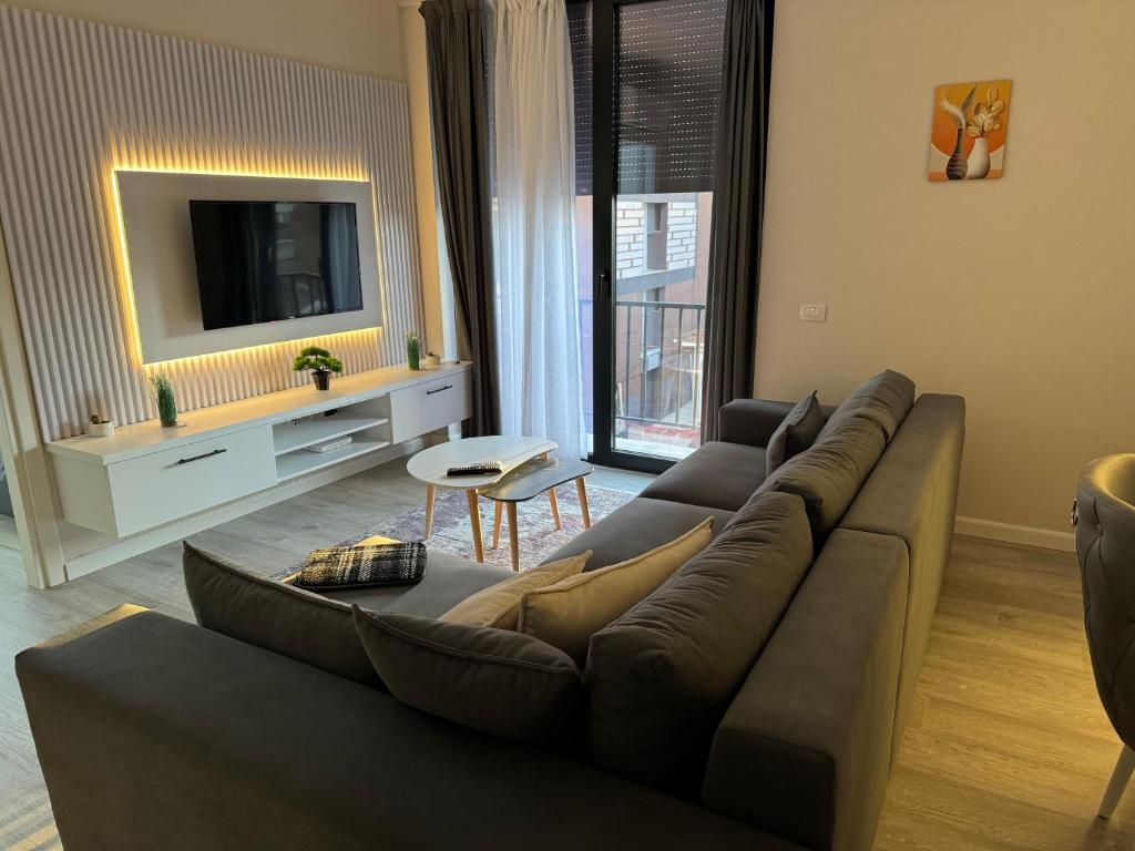 a living room with a couch and a tv at SC Tirana Centre Apartment in Tirana