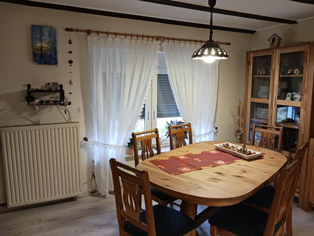 a dining room with a wooden table and chairs at Ferienwohnung Lücking im Westerwald in Flammersfeld