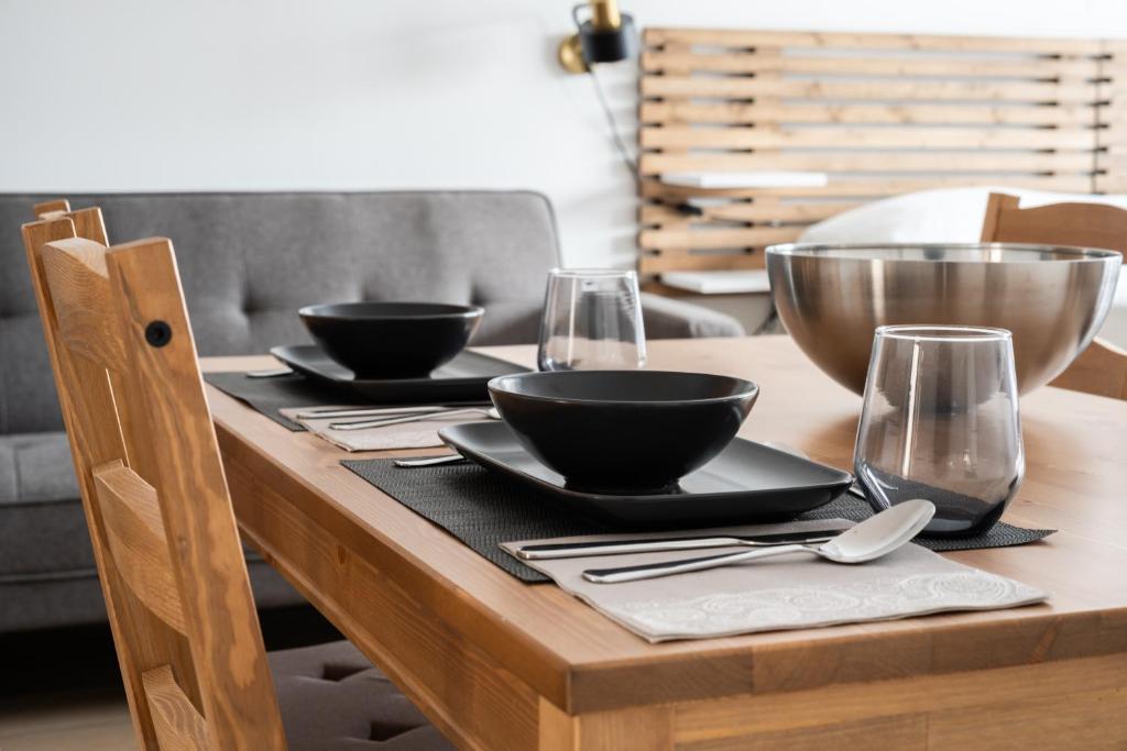 una mesa de madera con dos tazones y vasos. en Apartamentos GEMINA, en Mérida