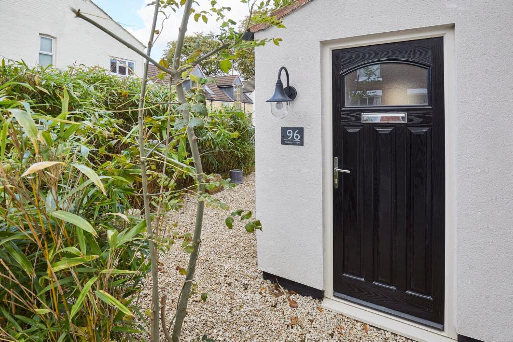 a black door to a house with a sign on it at Blossom Holiday Lets - 96 Roseberry Cottages in Guisborough