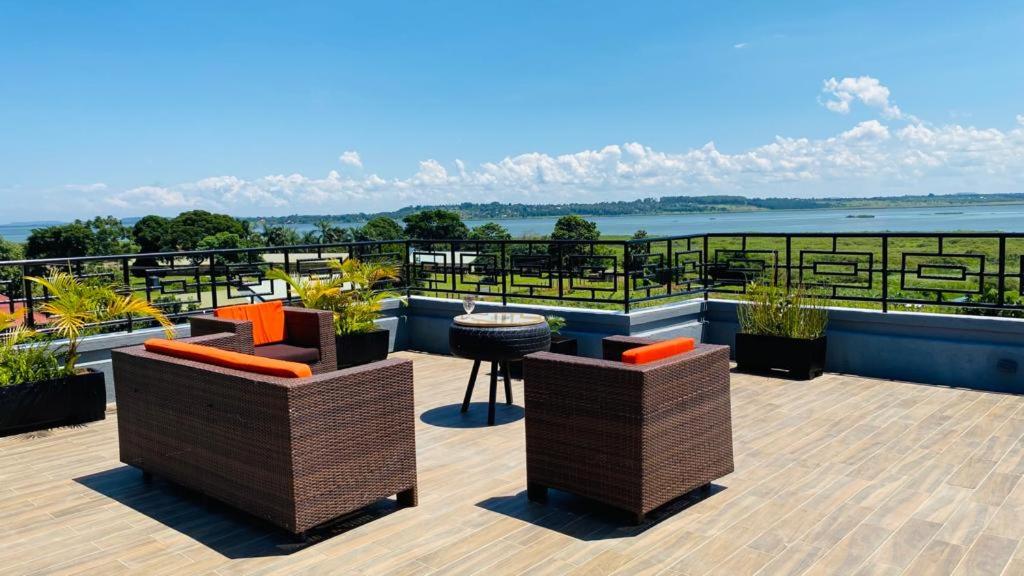 a patio with chairs and tables on top of a building at Nimaro Courts in Entebbe