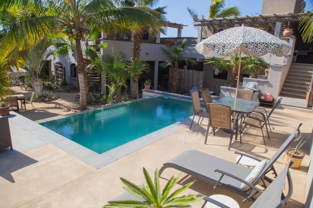 a patio with a table and chairs and a swimming pool at Pure Baja Suites and Retreats - Single Rooms in El Pescadero