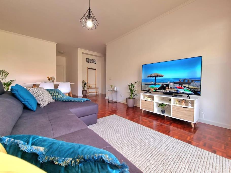 a living room with a large flat screen tv at Junto ao Mar - Apartamento T1 in Santa Cruz