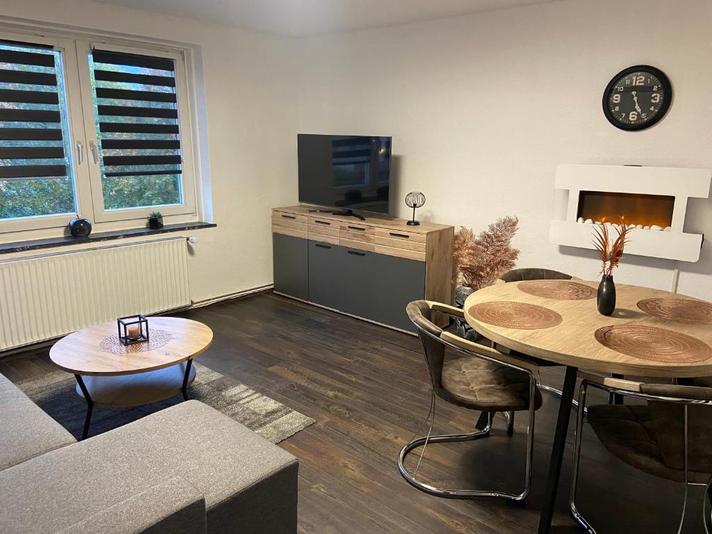 ein Wohnzimmer mit einem Tisch und einem TV in der Unterkunft Roségold in Bad Harzburg