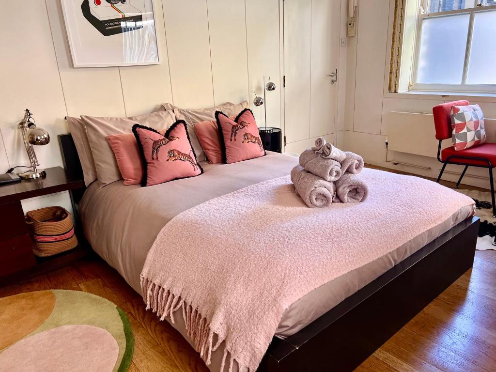 1 dormitorio con 1 cama grande con almohadas rosas en Shoreditch Private Studio, en Londres
